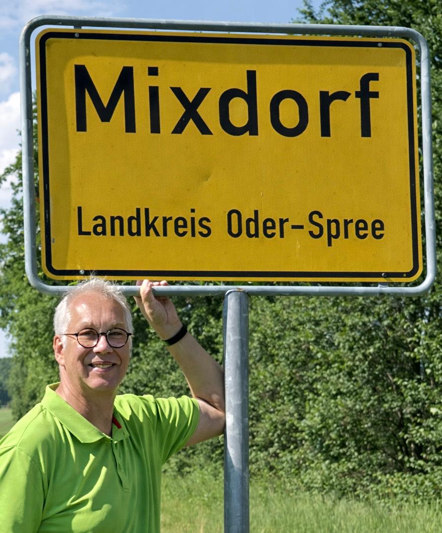 Ronny Mixdorf steht an einem Straßenschild mit der Aufschrift "Mixdorf"